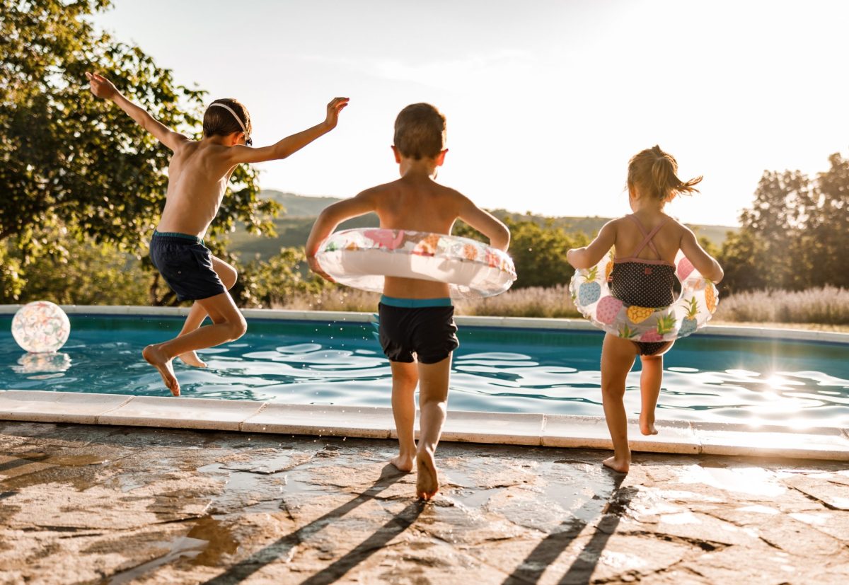 Playful siblings having fun during summer day at the pool.