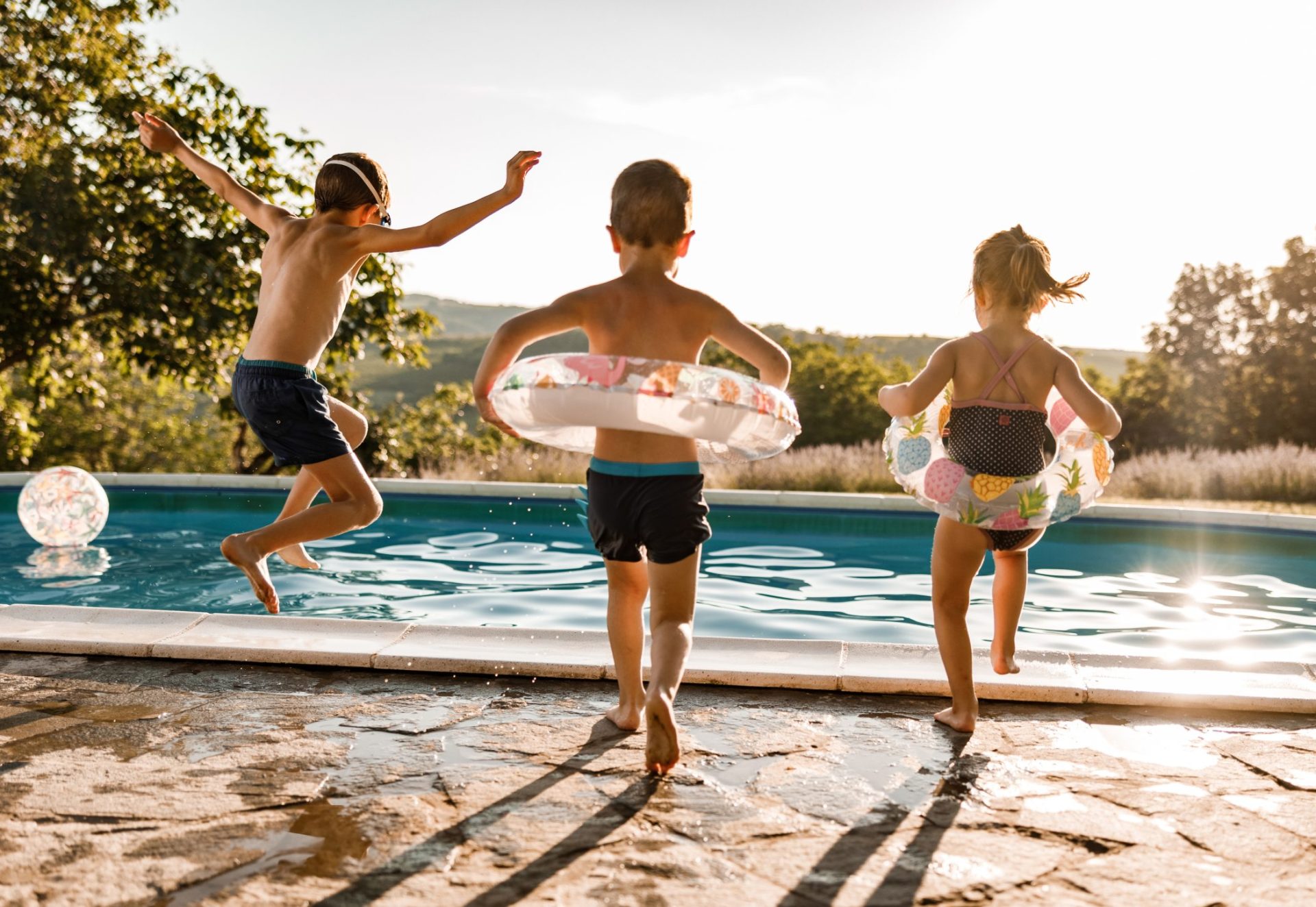 Playful siblings having fun during summer day at the pool.